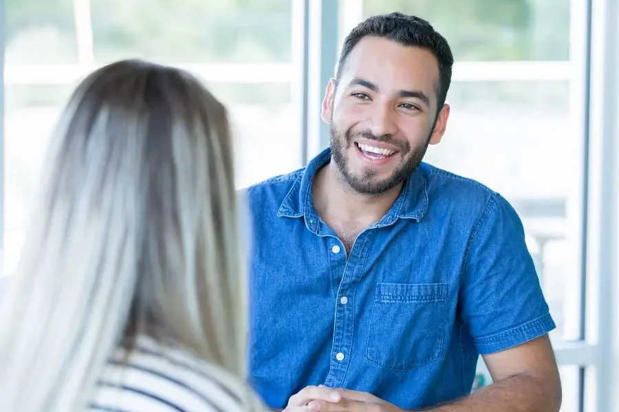 Smiling man talking to woman