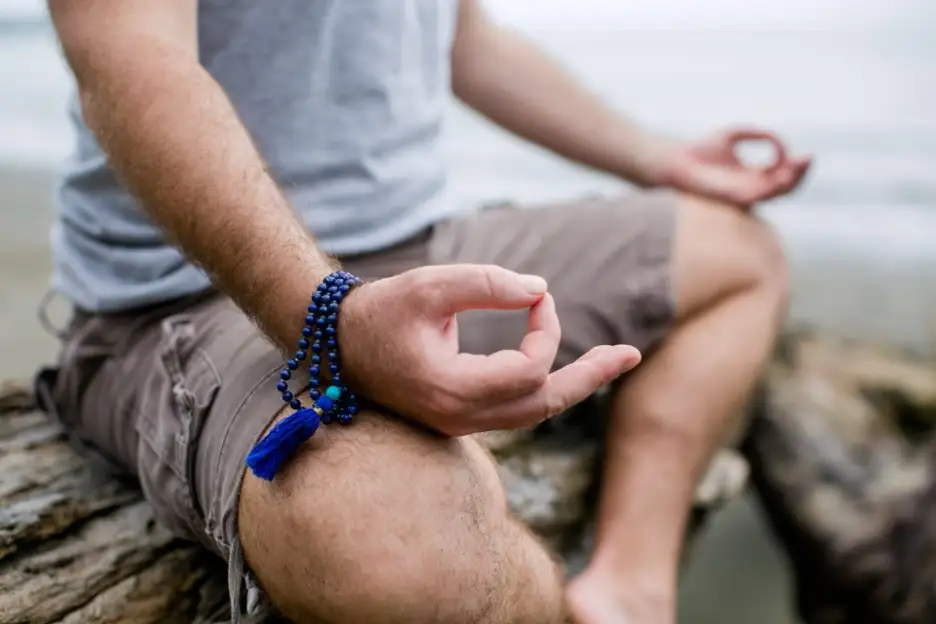 A person meditating on a rock