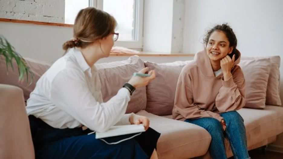 A person sitting on a couch and talking to a person