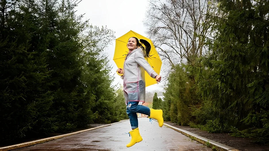 A person jumping in the air with a yellow umbrella