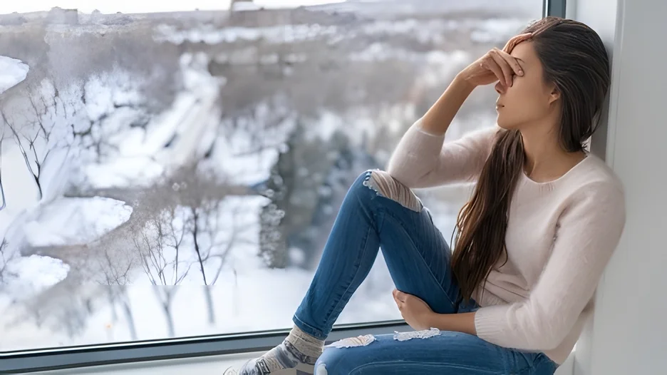 A person sitting on a window sill