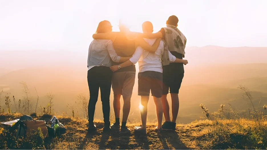 A group of people hugging on a hill