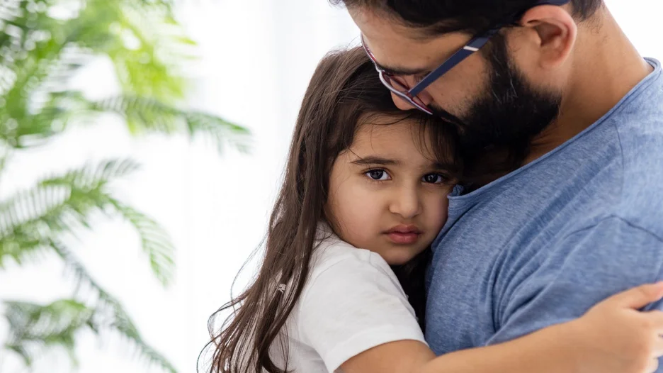 Man with beard holding a younger girl