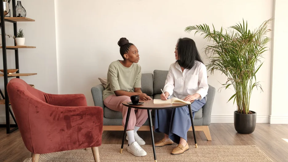 Two people sitting together on a sofa and talking