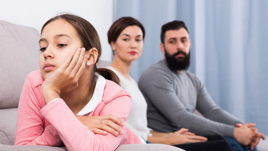 Teenager looking away with parents in the background
