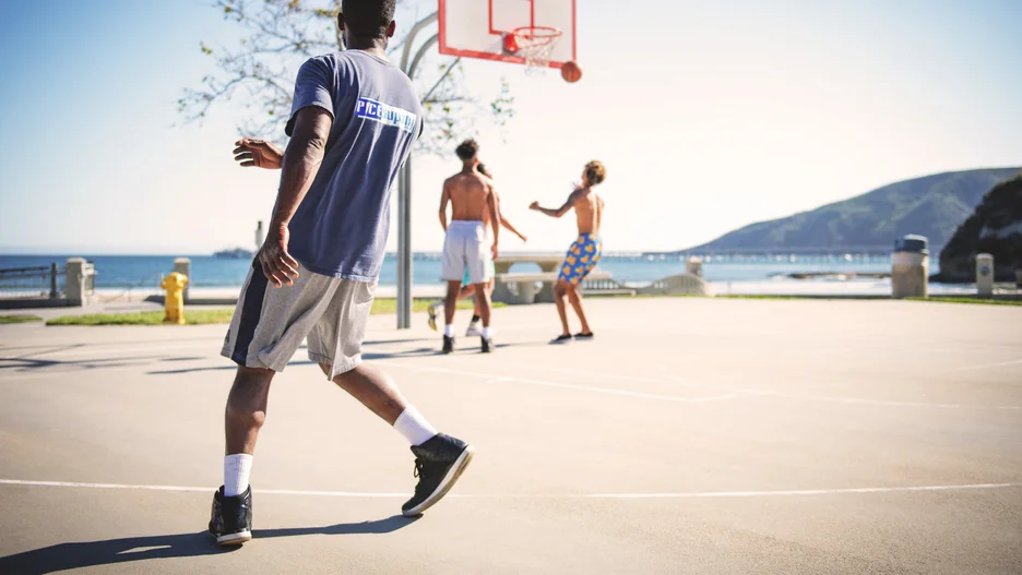 Four people playing outdoor basketball